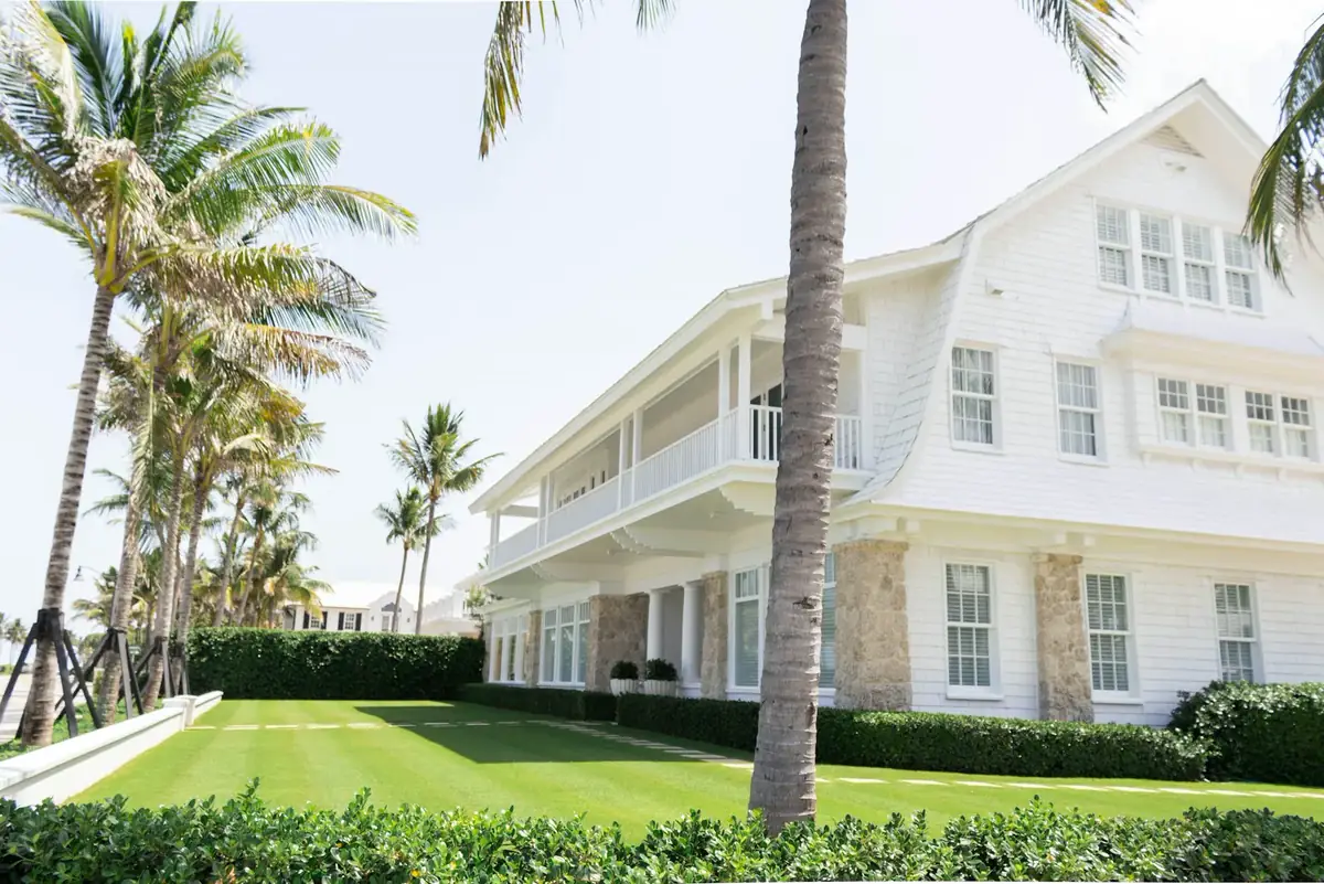 Coastal South Florida home with palm trees and many windows